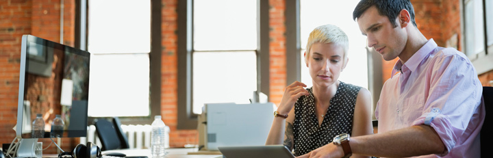 Man and woman working in front of a computer